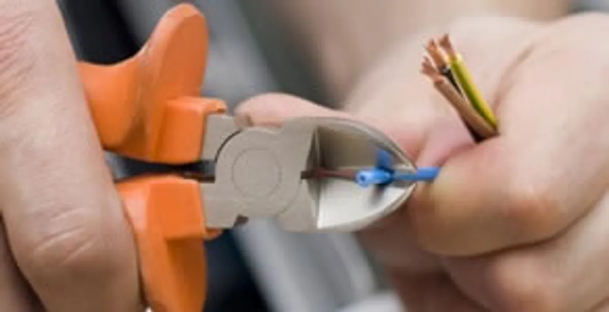 licensed electrician performing precise wire cutting and preparation during electrical service in Houston, TX