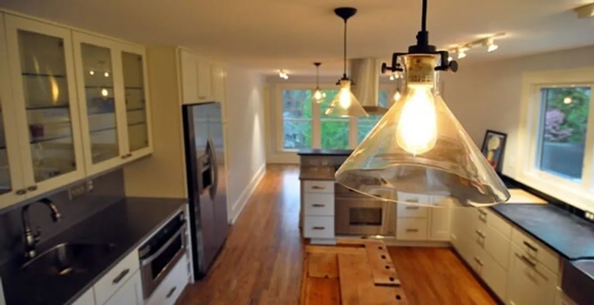 Residential electrician installing modern indoor light fixture in a home in Houston, TX